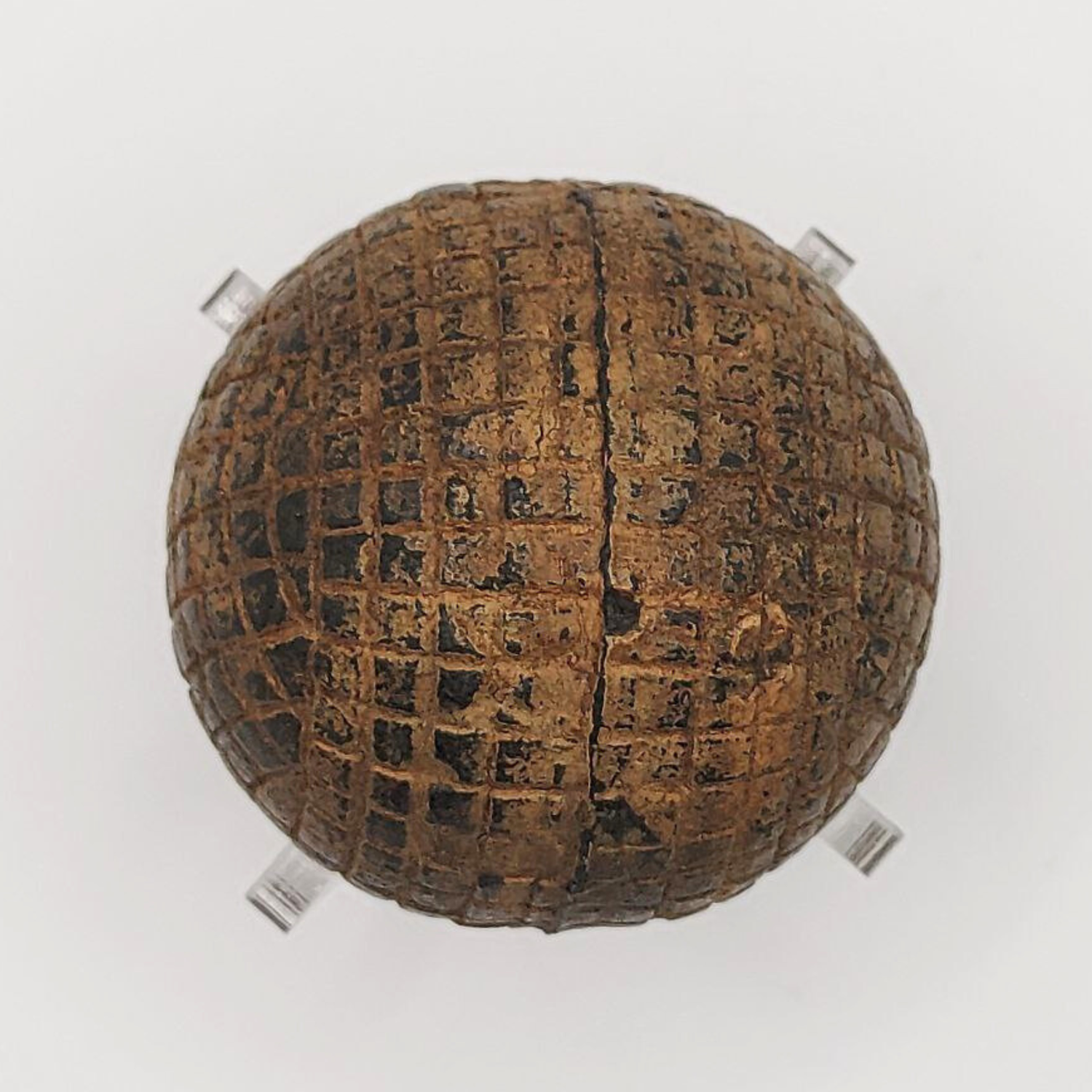 A top view of an antique line-cut golf ball made from gutta percha rubber. 