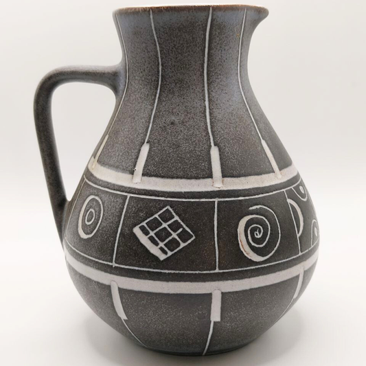 Grey ceramic jug with geometric patterns on a white background
