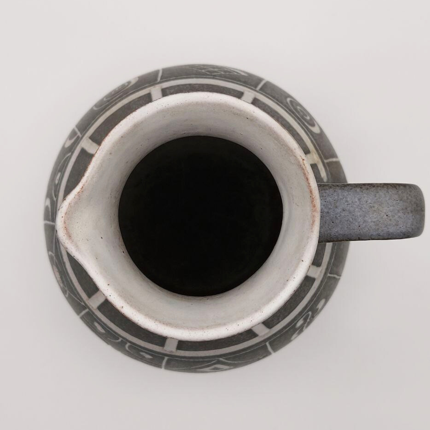 Ceramic jug top view with geometric patterns on a white background