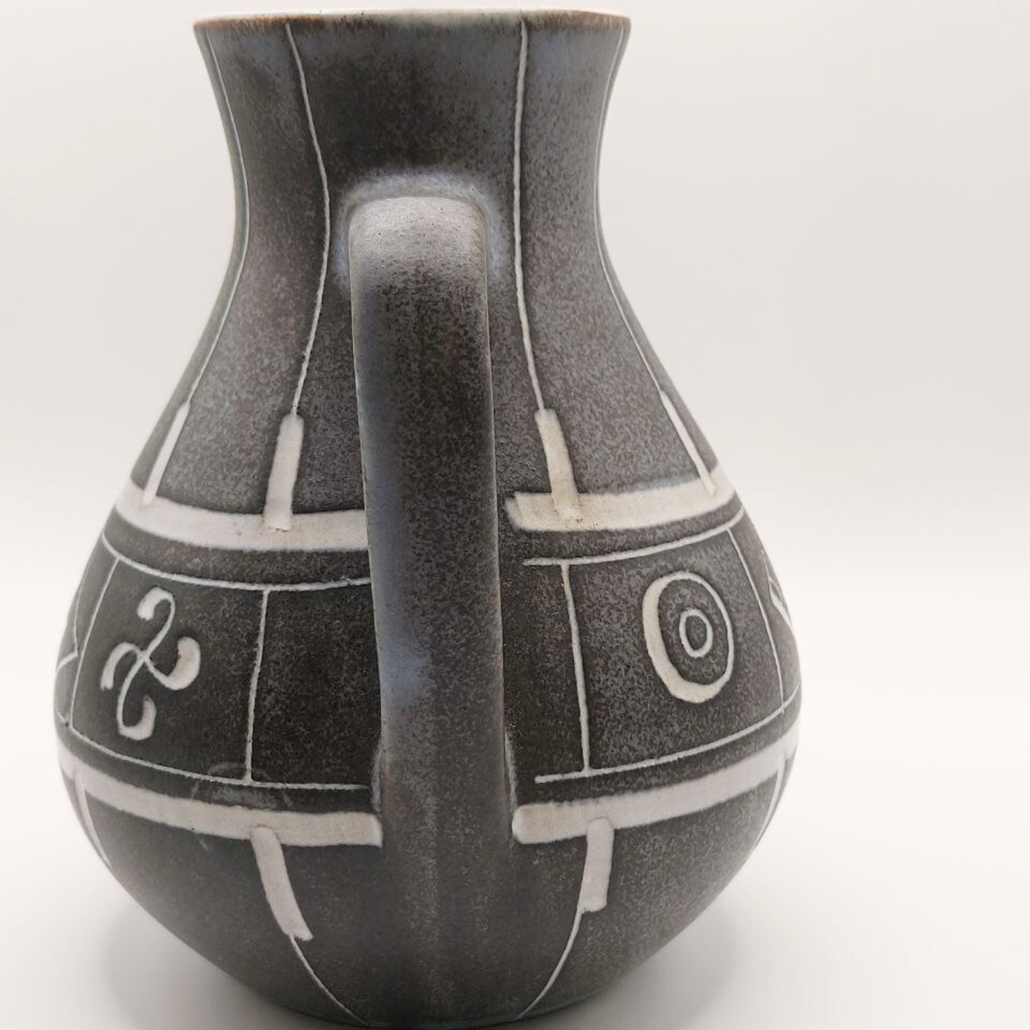 Ceramic jug with decorative patterns on a white background