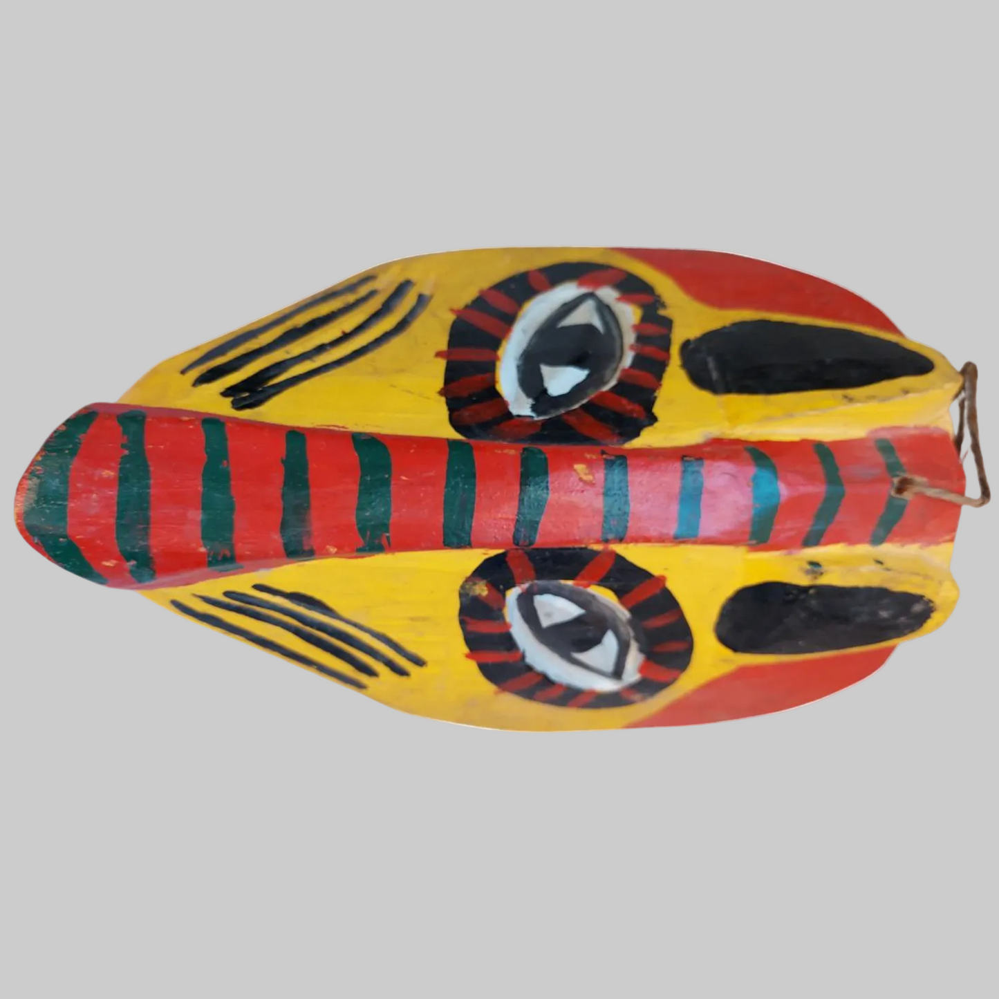 A side view of a vintage wooden Mexican tiger mask