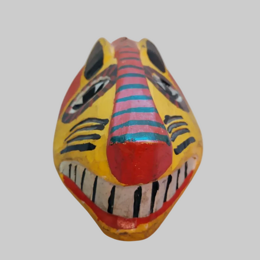 A colourful wooden mask of a tiger on a light grey background. 