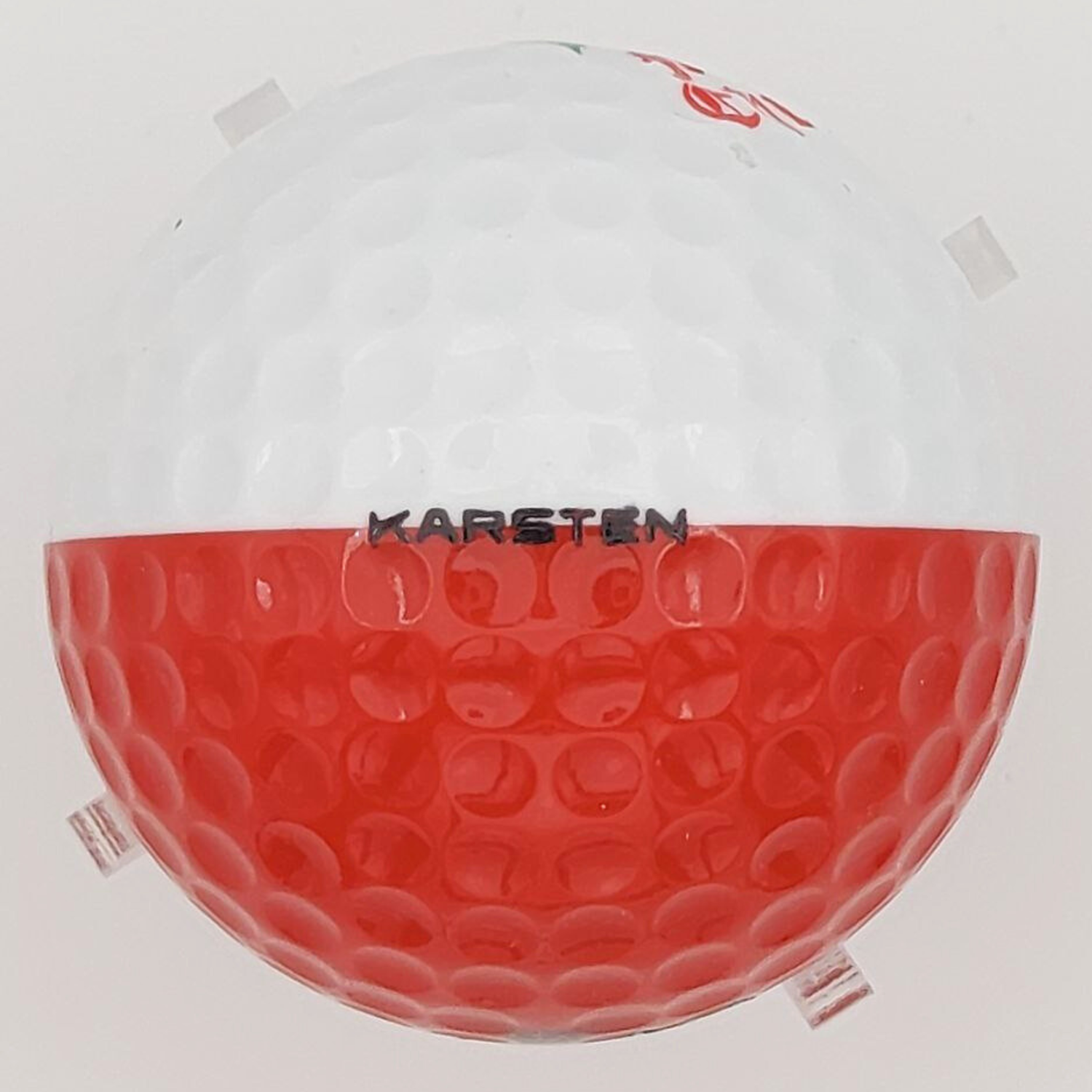 Golf ball with red and white design on a light gray background