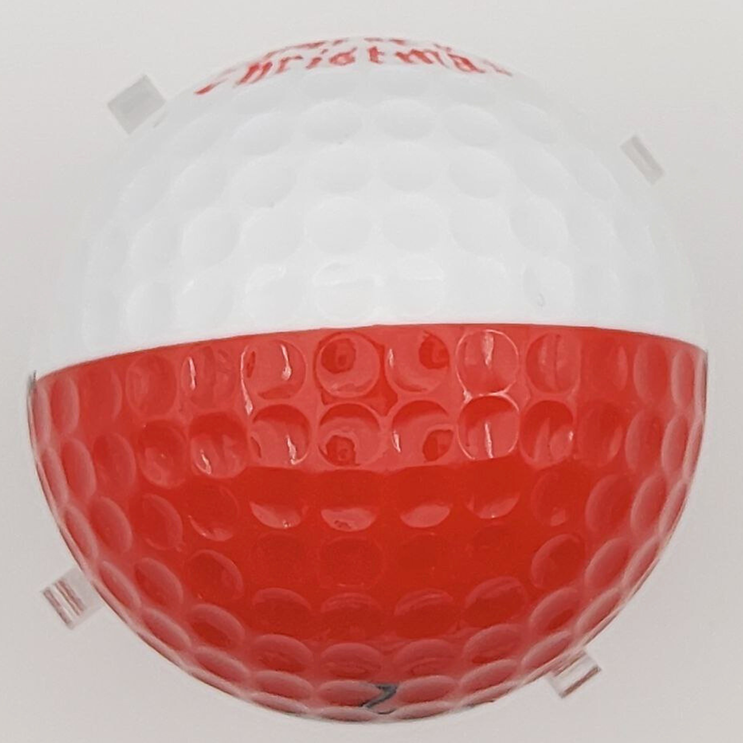 Golf ball with red and white design on a white background