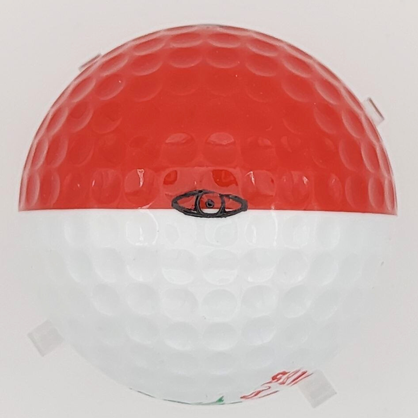 Red and white golf ball with an eye logo on a light grey background
