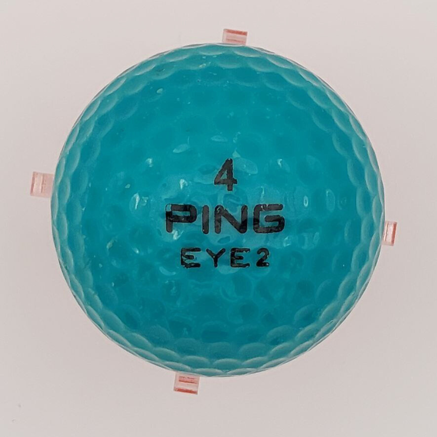 Teal golf ball with 'PING' branding on a white background