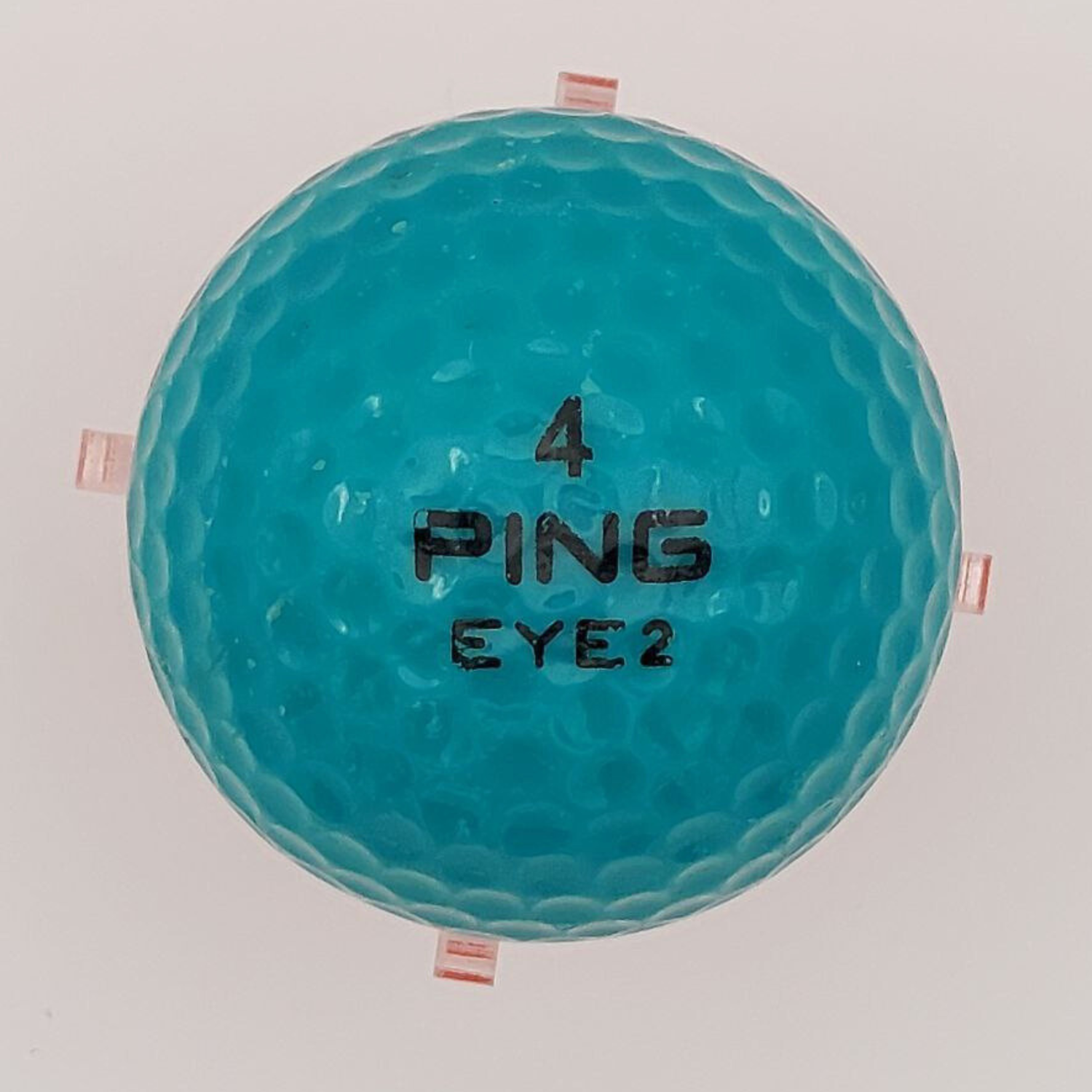 Teal golf ball with 'PING' branding on a white background