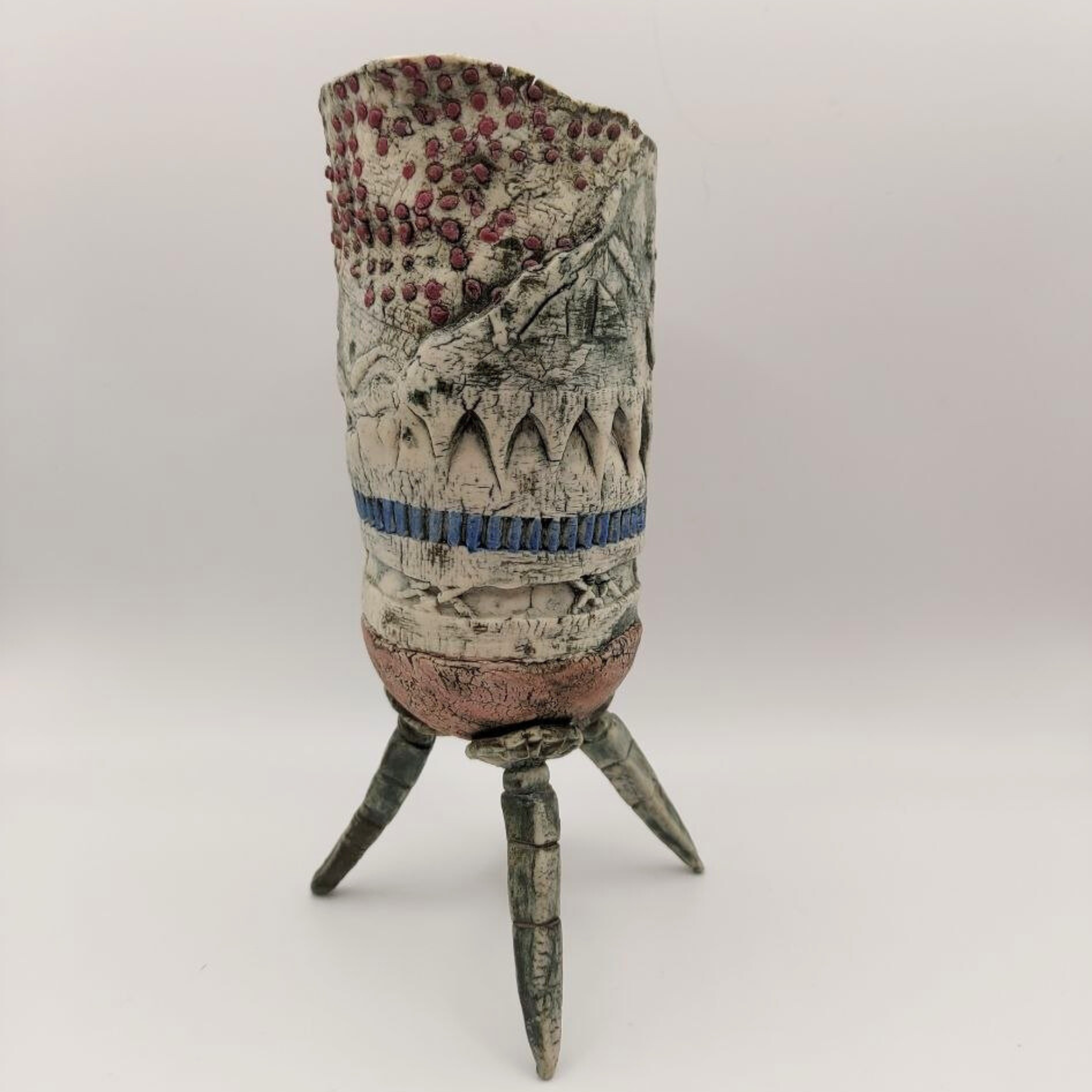 A stunning vase on a tripod base against a grey background