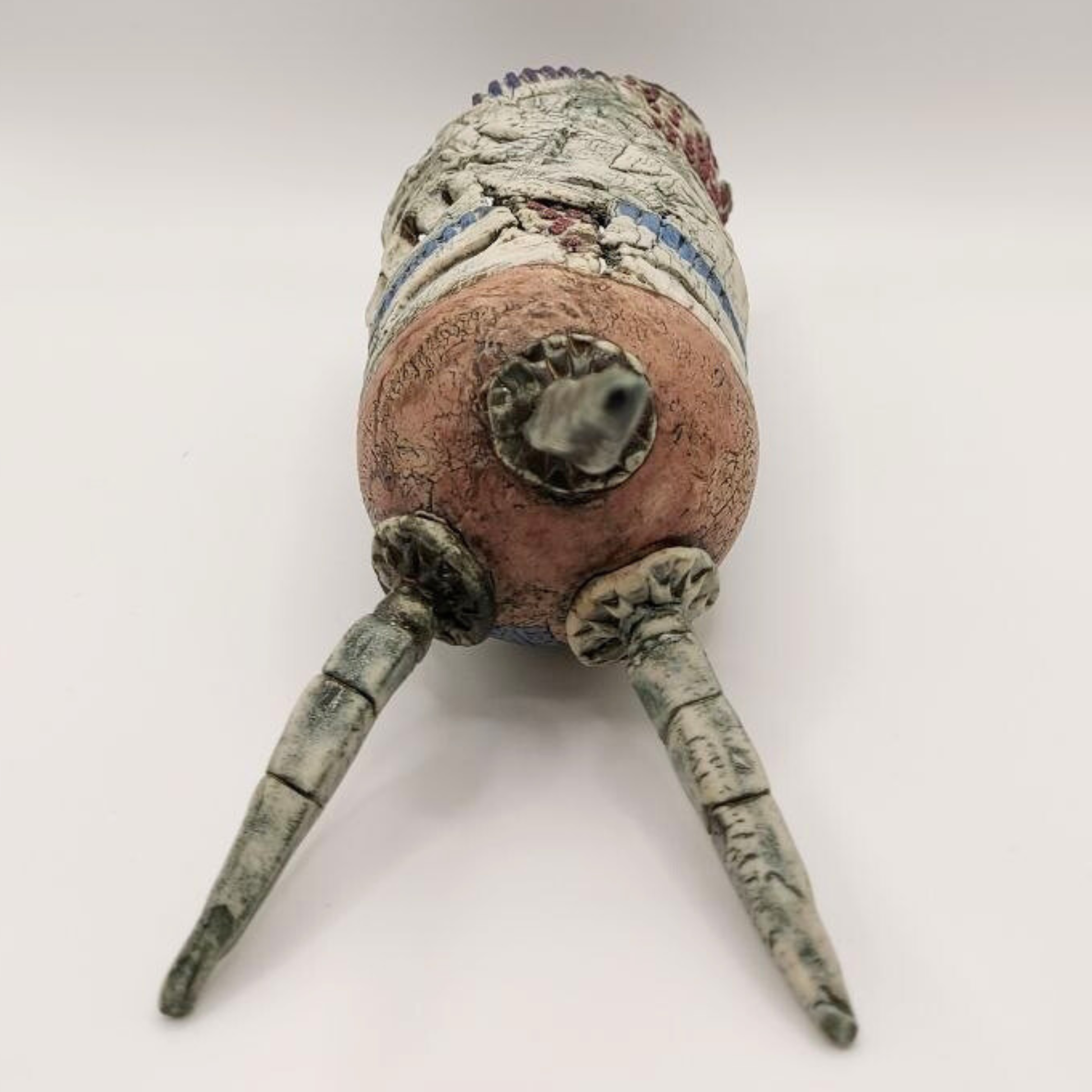 The tripod base of a vase by Pam Schomberg against a grey background