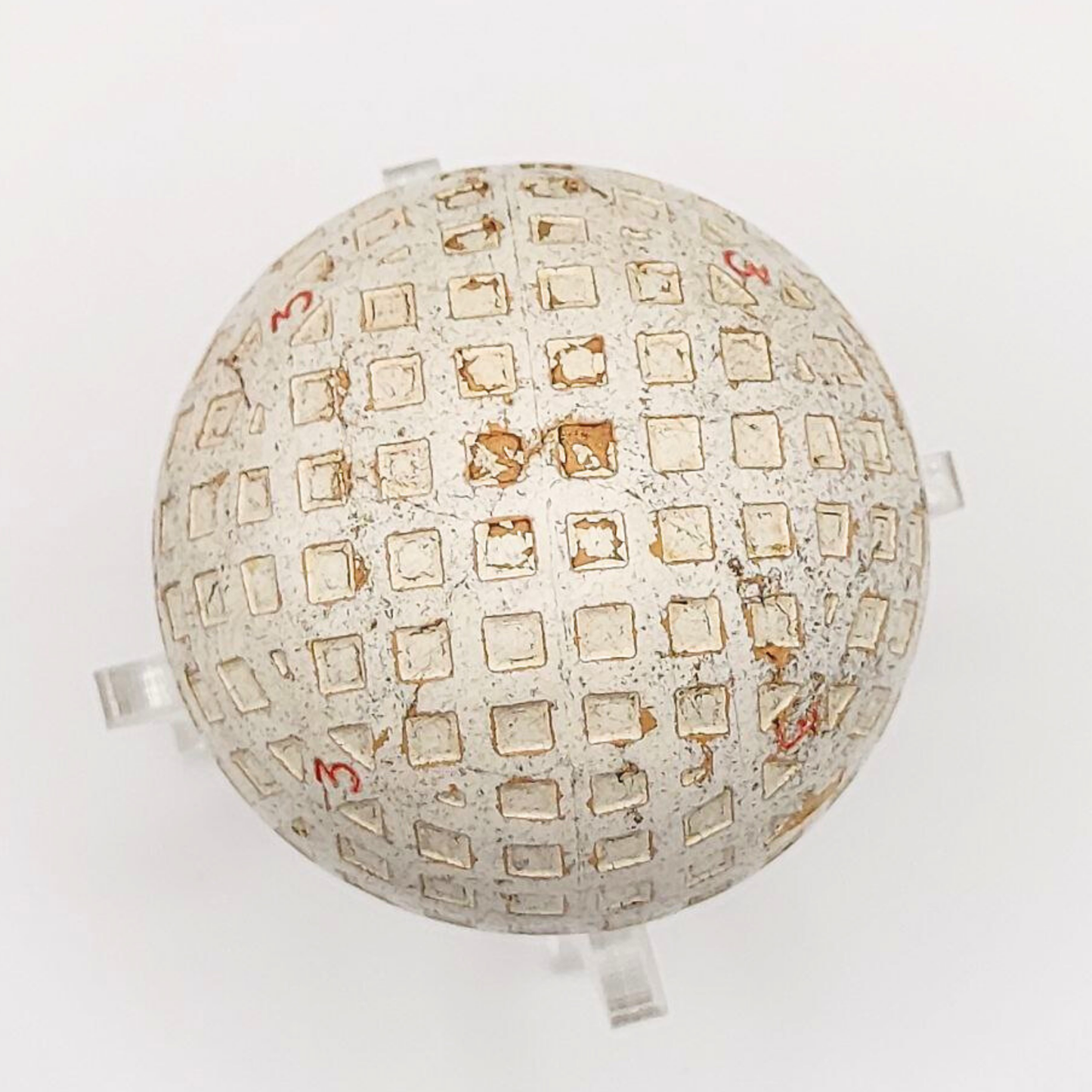 A vintage golf ball set against a white background. 