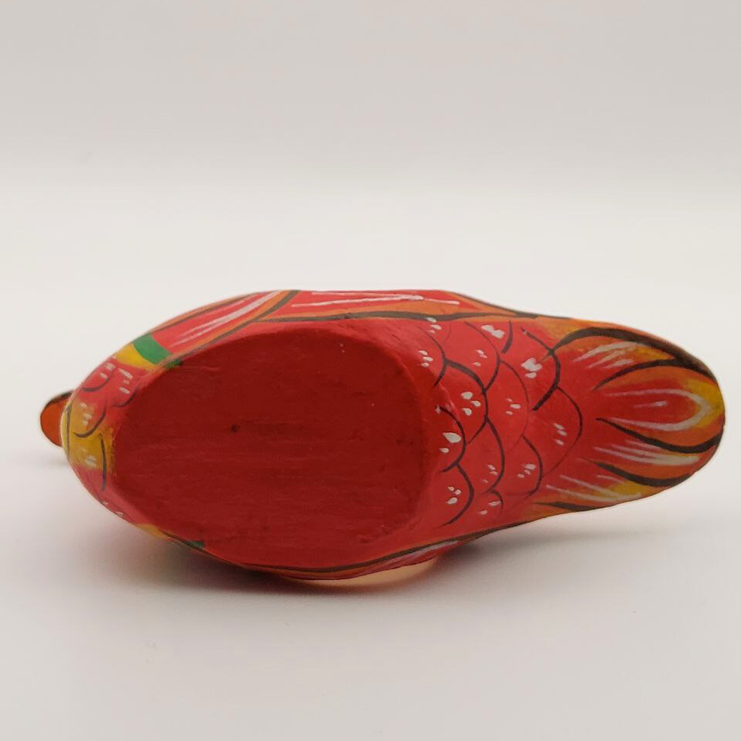 The base of a red duck napkin holder on a white background