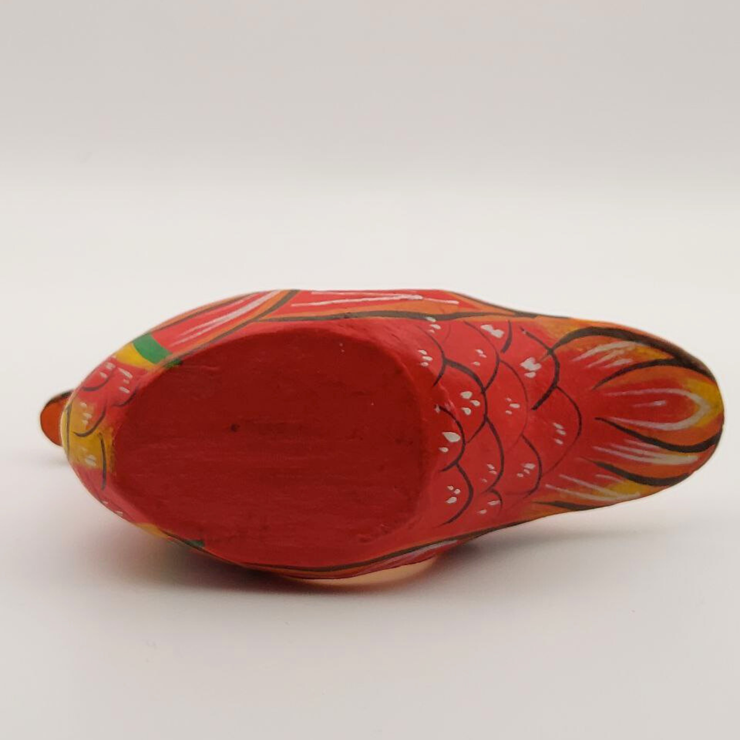 The base of a red duck napkin holder on a white background