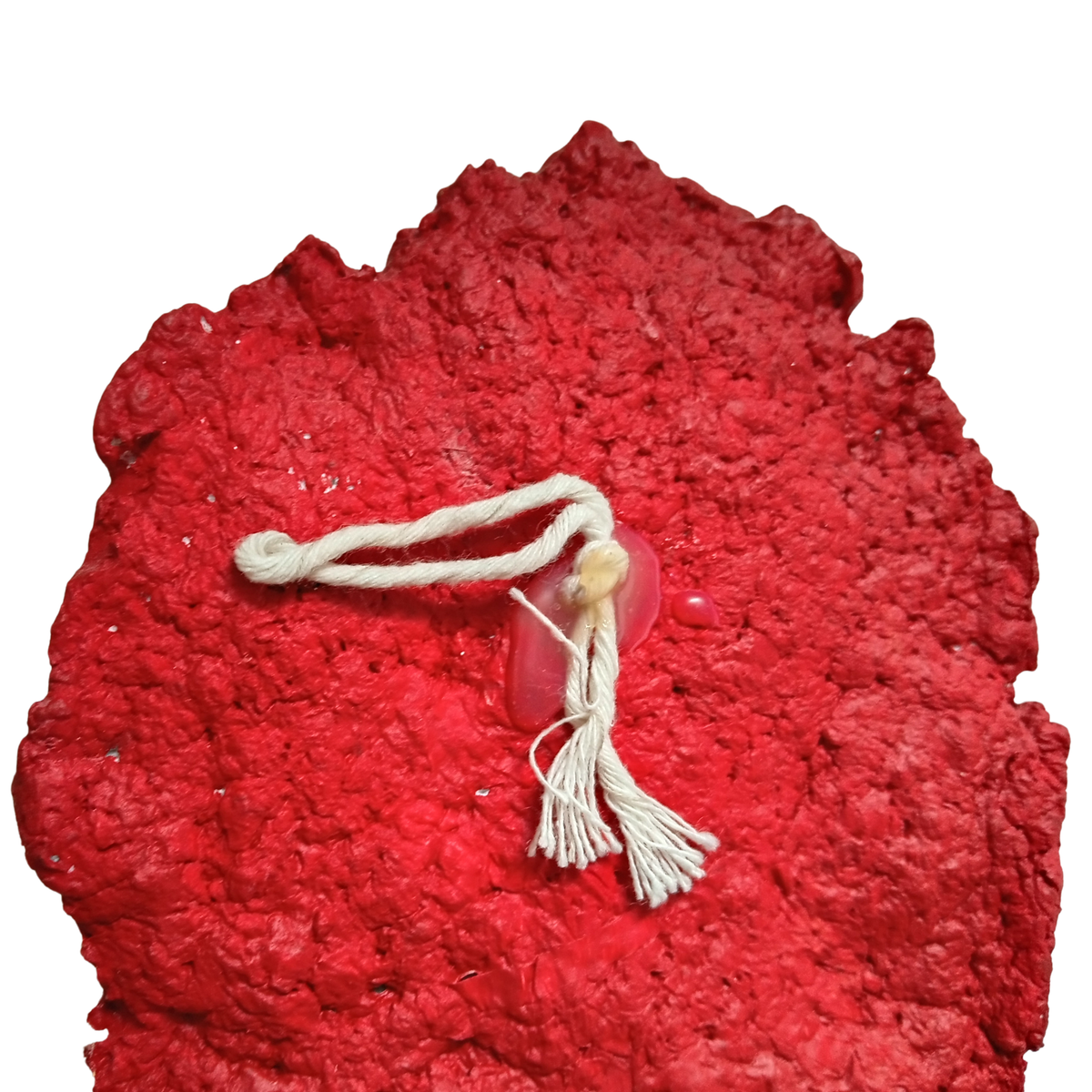 A textured red hanging mask sculpture with a white rope tassel and a small translucent plastic hook attached, shown against a plain white background.