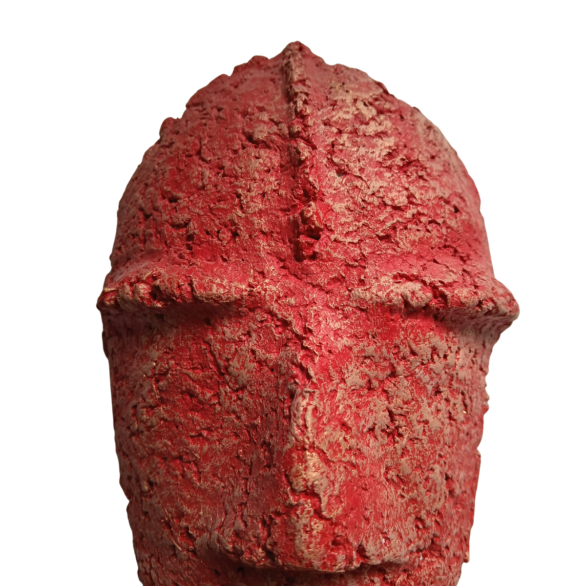 A close-up of a textured red mask with a cross-like protrusion at the top centre, isolated on a white background.