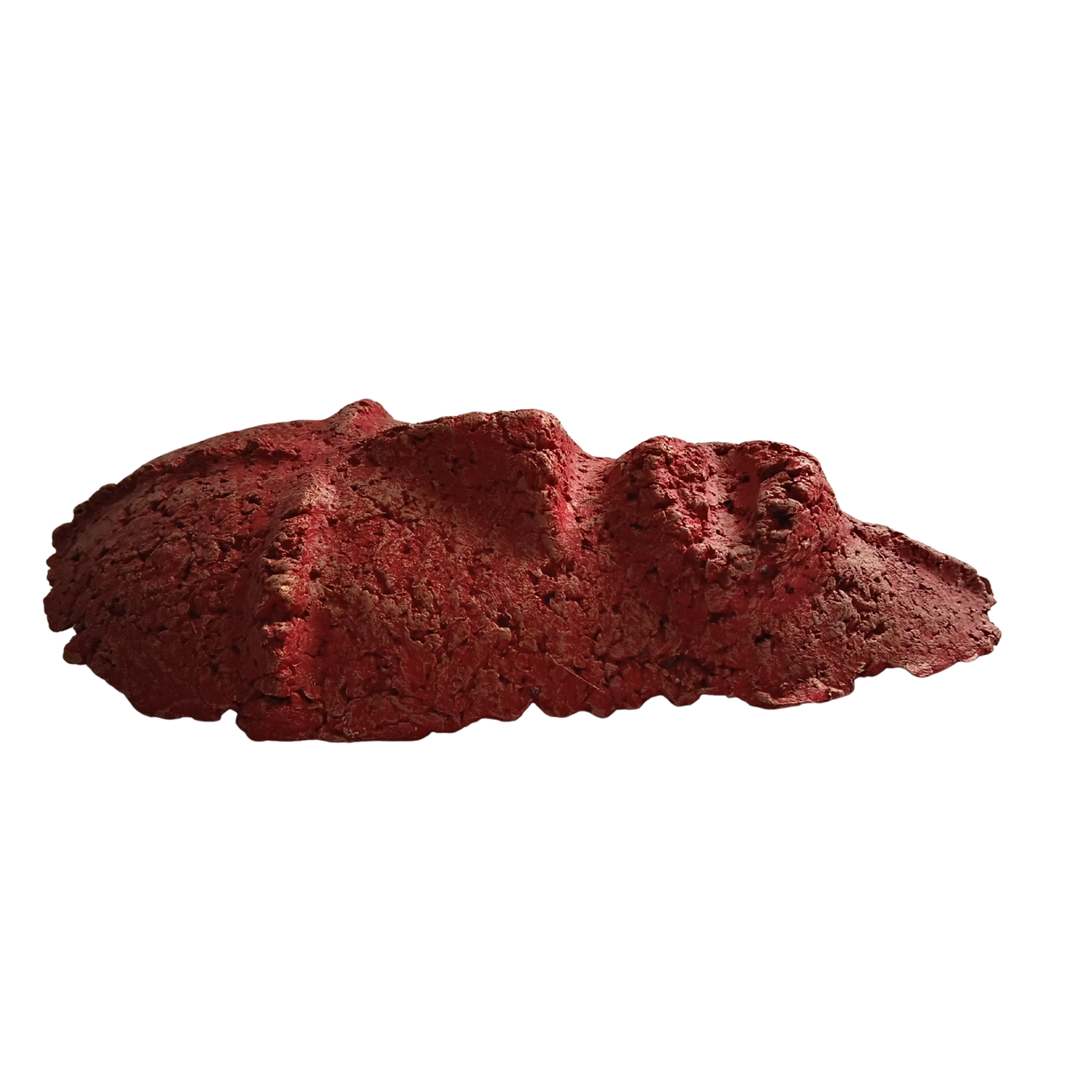 A textured red decorative mask sculpture with a rough, organic surface, shown against a plain white background.
