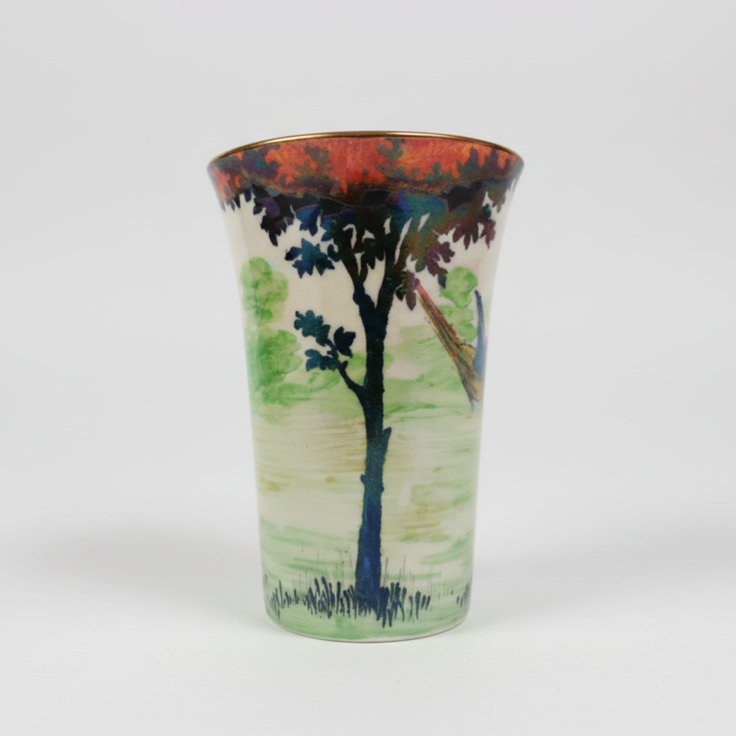 Ceramic vase with a scenic design of a tree and landscape on a white background