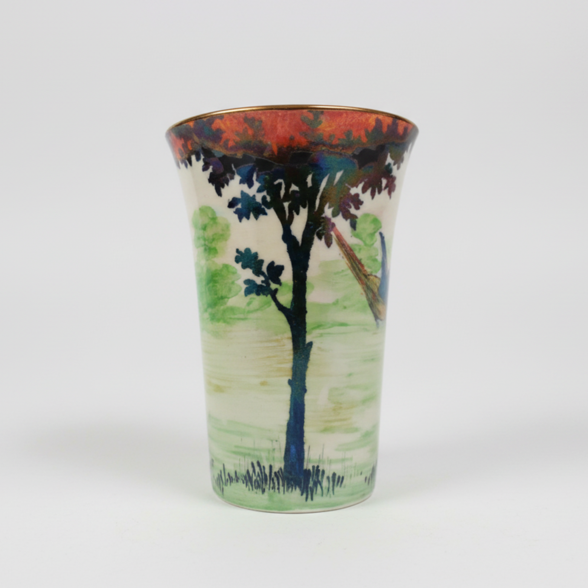 Ceramic vase with a scenic design of a tree and landscape on a white background