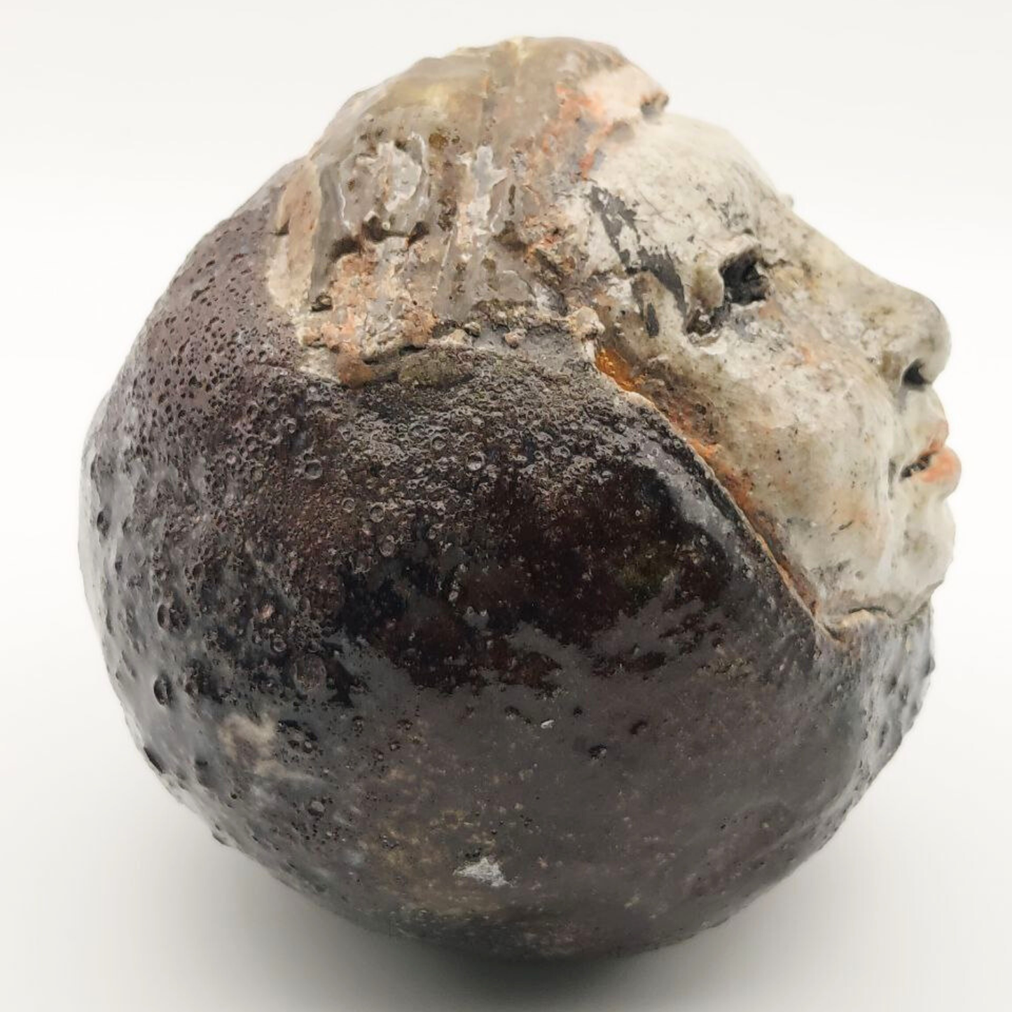 Close-up of a textured, dark brown object on a white background