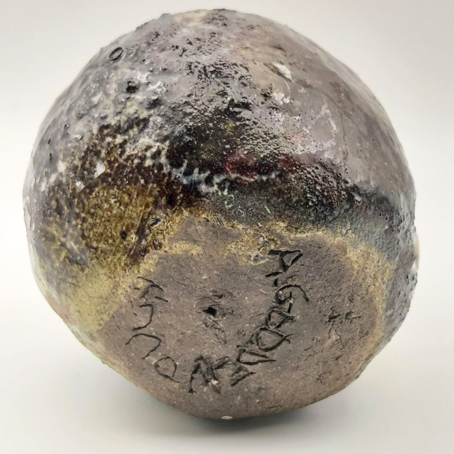 Textured clay bust with inscriptions on a white background