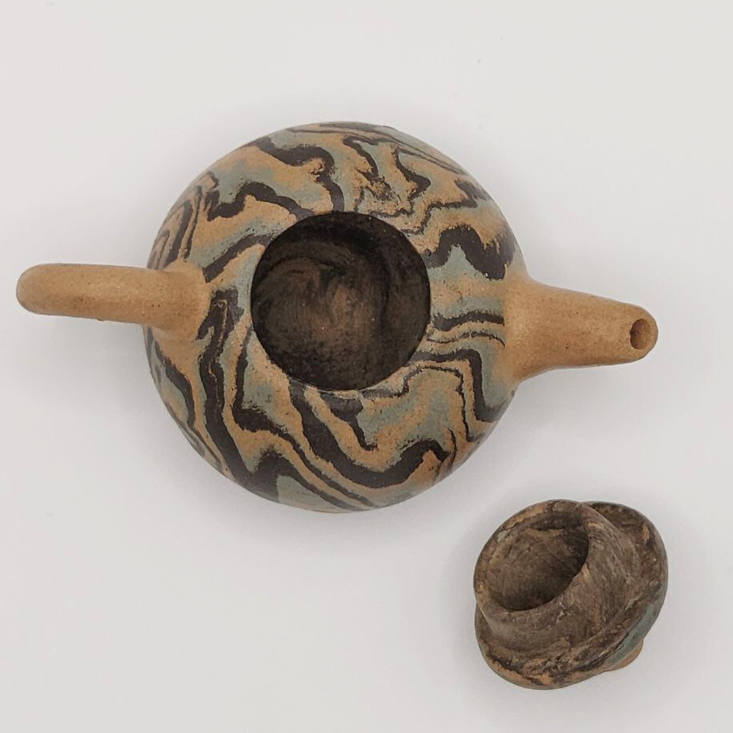 A patterned mini Chinese clay teapot on a white background