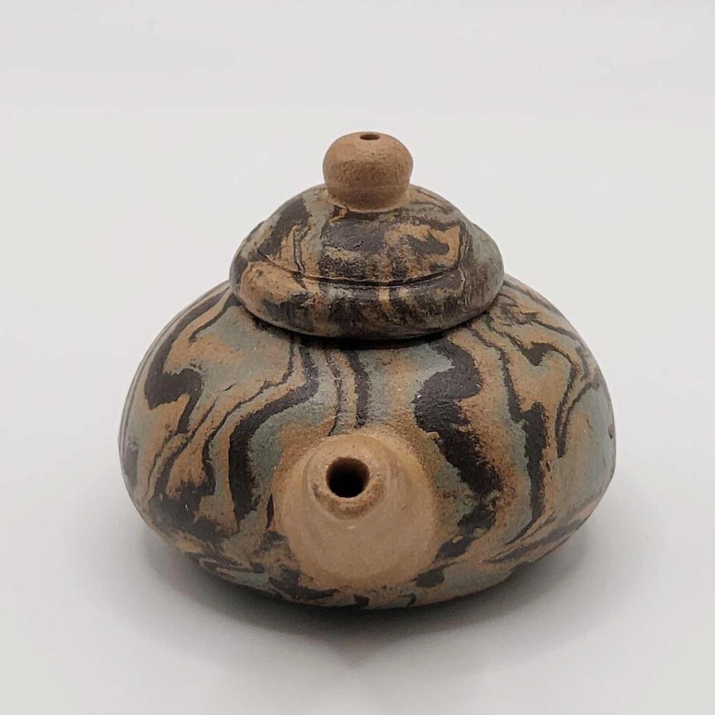 A patterned mini Chinese clay teapot on a white background