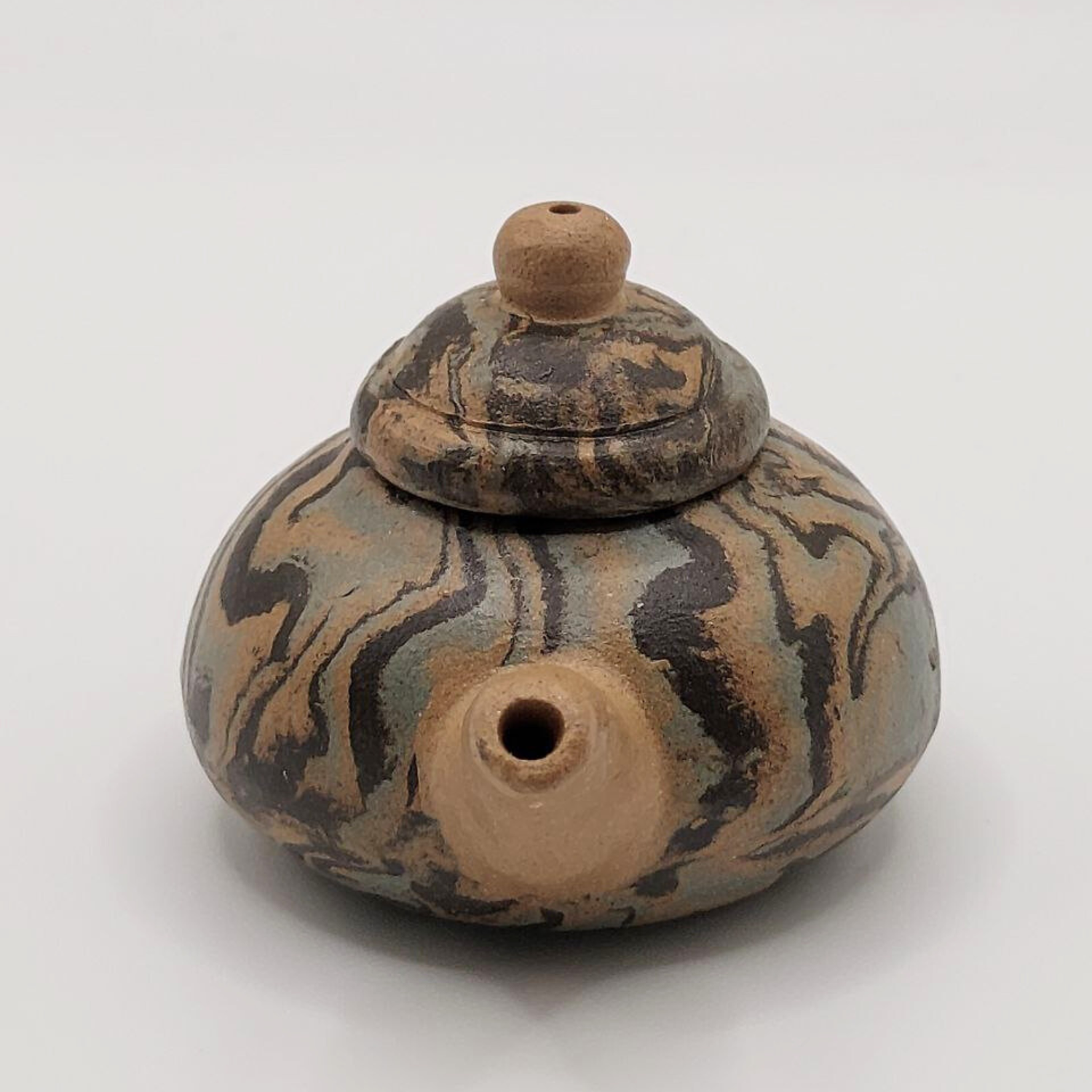 A patterned mini Chinese clay teapot on a white background