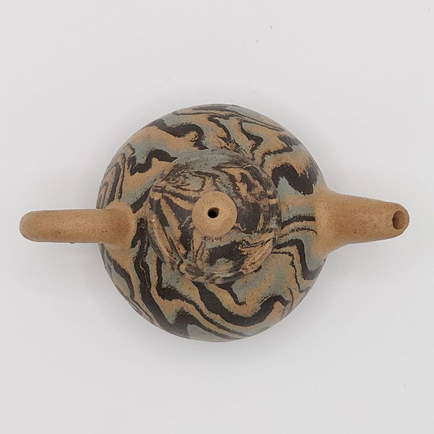 A patterned mini Chinese clay teapot on a white background
