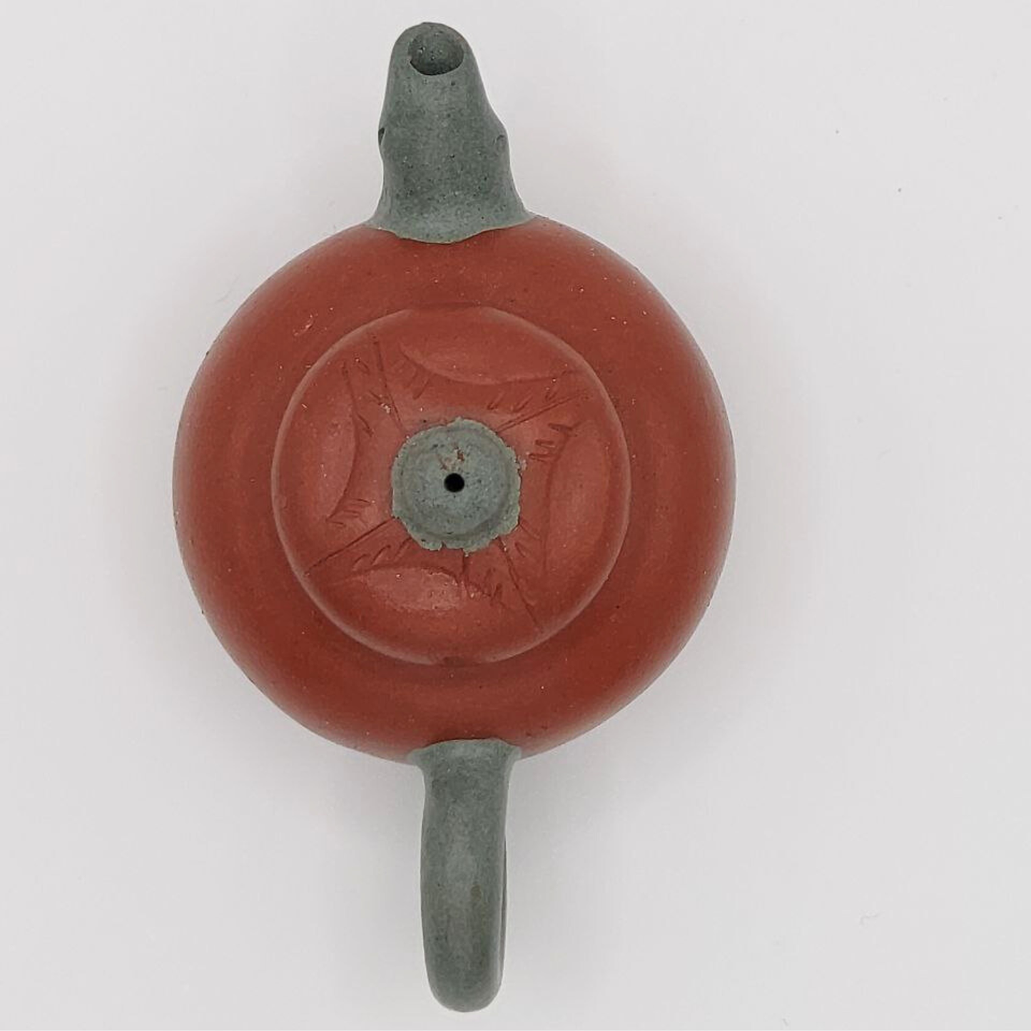 A red and green mini Chinese clay teapot on a white background