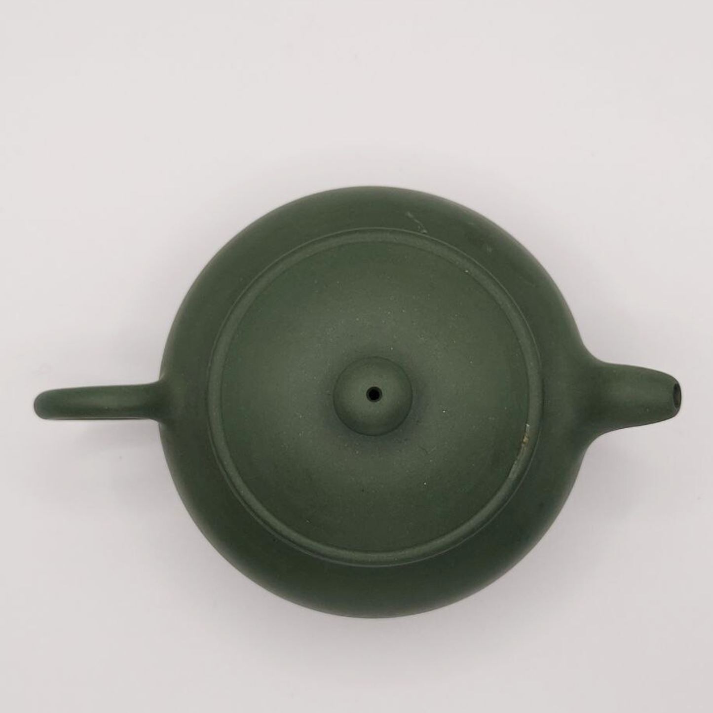 A green mini Chinese clay teapot on a white background