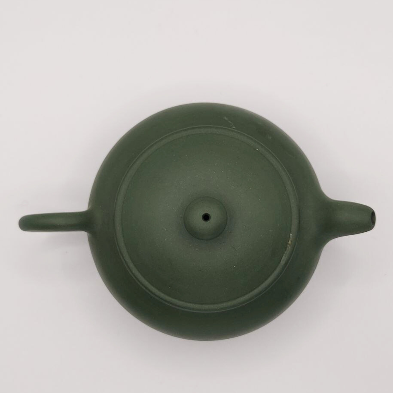 A green mini Chinese clay teapot on a white background