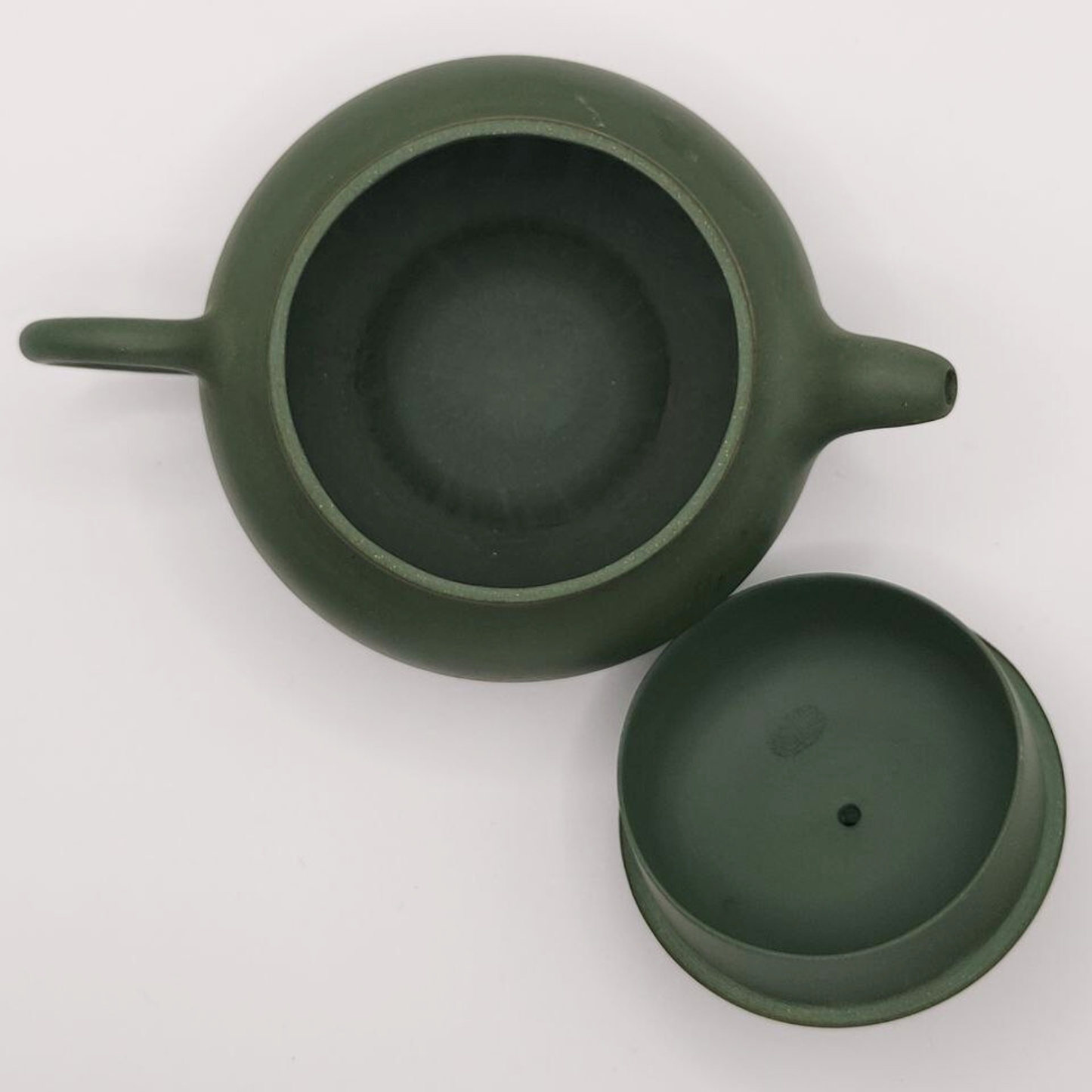 A green mini Chinese clay teapot on a white background