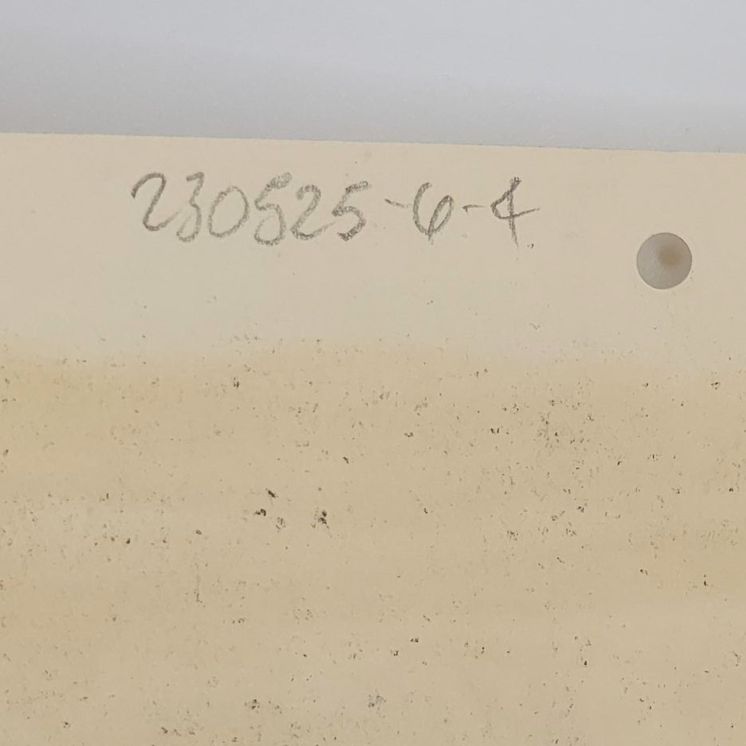 Beige art paper with a number and letter code on a white background