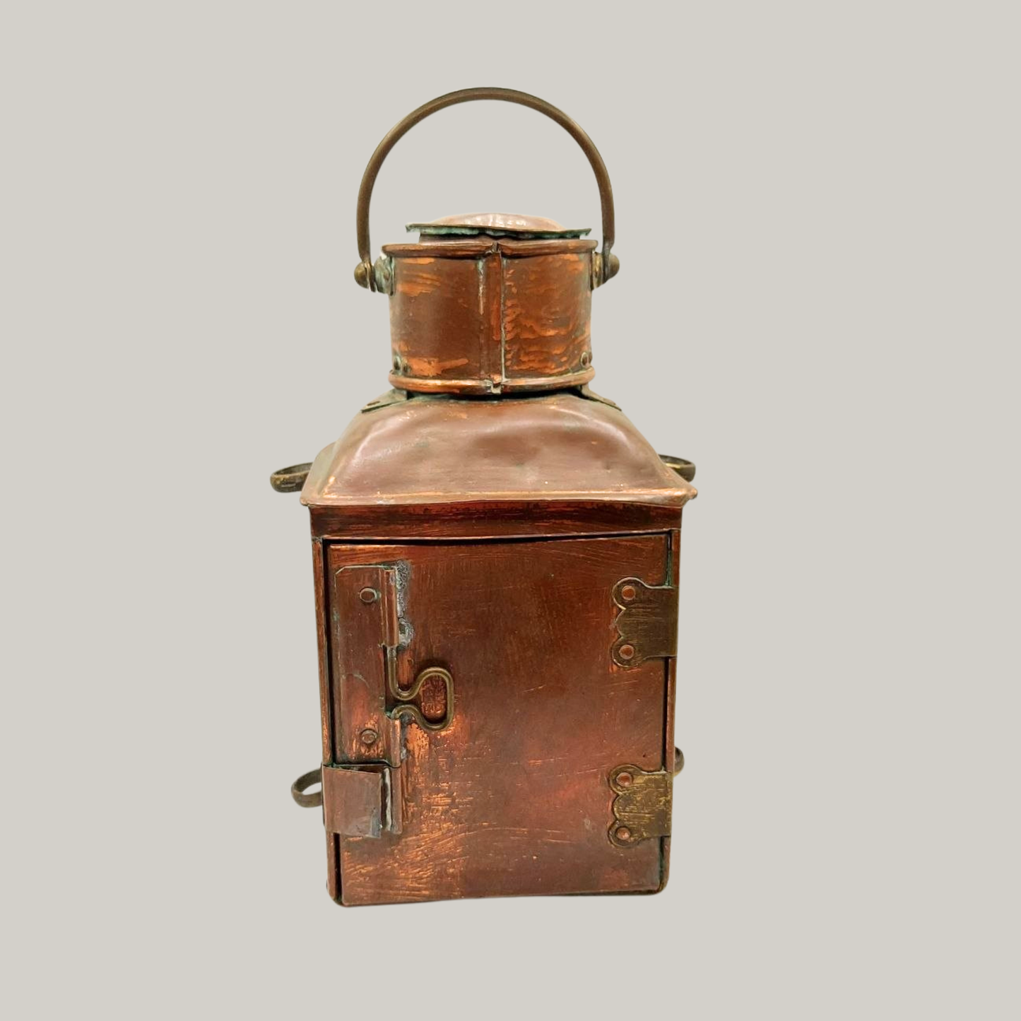 Vintage copper lantern with a handle on a grey background