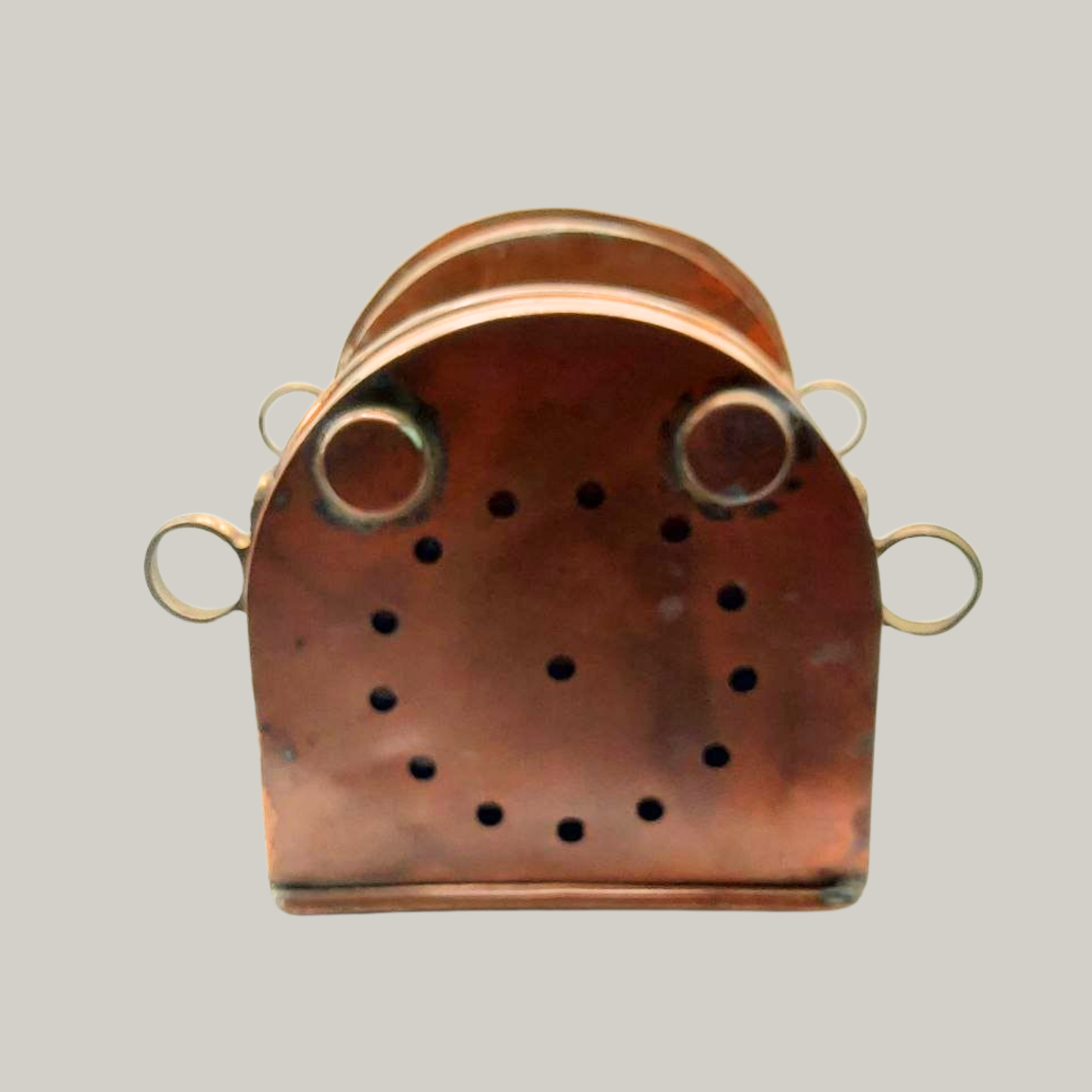 The base of a copper lantern on a grey background