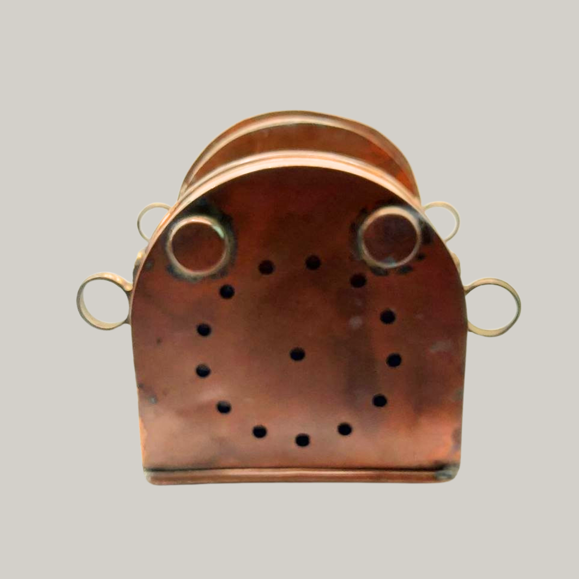 The base of a copper lantern on a grey background