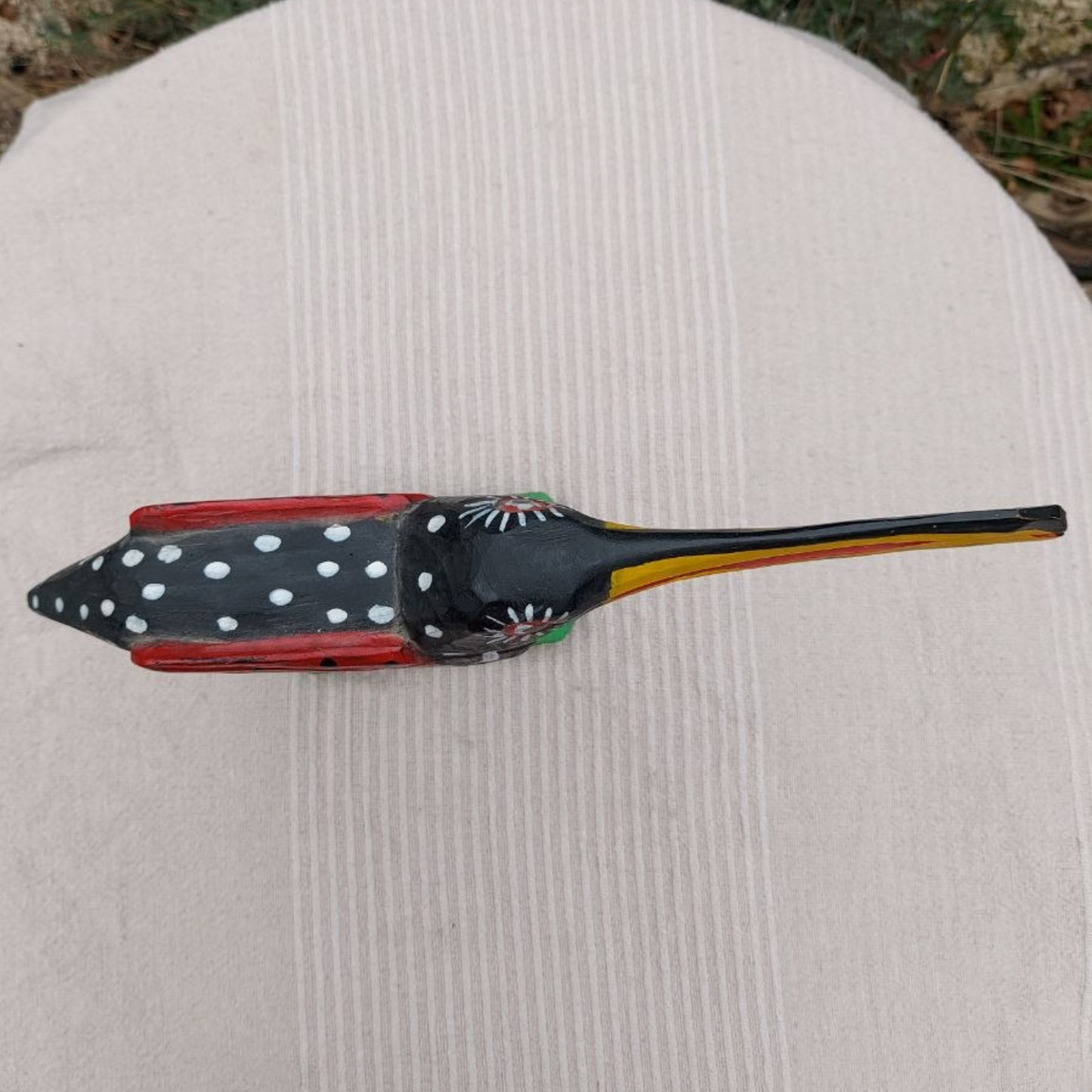 Decorative wooden toucan with polka dot design on a textured surface